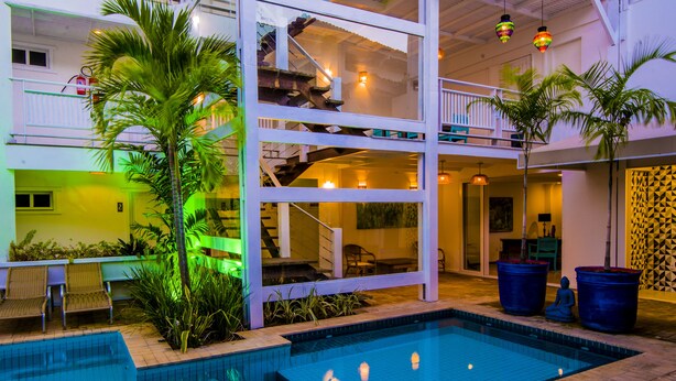 Una piscina interior de estructura escalonada, con palmeras y zonas de estar.