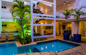Una piscina coperta a più livelli, con palme e zone relax.