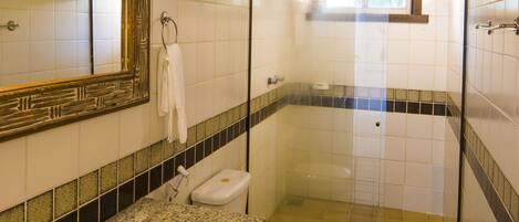 A bathroom with a sink, toilet, and shower area.