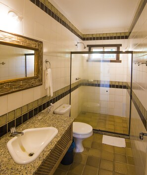 Une salle de bain comprenant un lavabo, des toilettes et un espace douche.