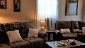 Ein Wohnzimmer mit zwei braunen Sofas, einem Couchtisch und einer Lampe.