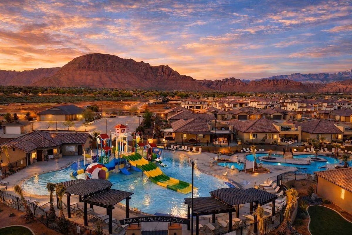 Een resort met meerdere zwembaden, een waterpark en een bergachtige achtergrond.