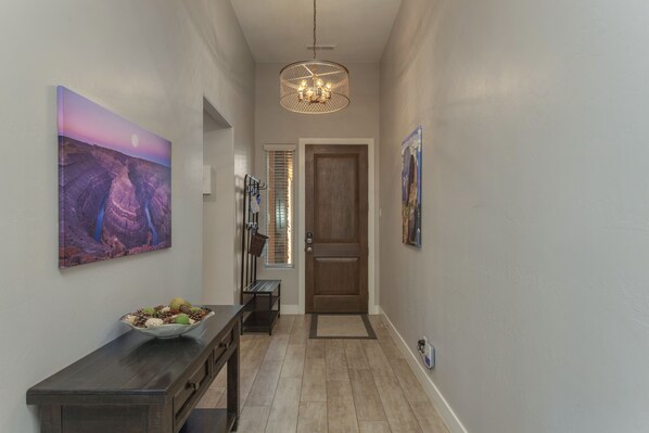 A hallway with a wooden bench, a bowl of fruit, and a door at the end. - Paradise Village Resort 111: Private Hot Tub, Fire Pit, Nintendo Switch, Ping Pong, Community Pool (Santa Clara)