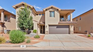 A two-story house with a garage, a balcony, and a well-maintained front yard with landscaping. - 94 PV, Luxury Home with Private Pool & Hot Tub, Fire Pit, Huge Kitchen, and More! (Santa Clara)