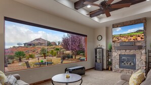 A living room with a large window, a fireplace, and a ceiling fan. - Coral Ridge Resort 1919, Across from Clubhouse and Pools! Golf Course Views (Washington)