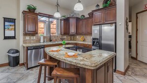 A kitchen with granite countertops, stainless steel appliances, wooden cabinets, and pendant lighting. - Coral Ridge Resort 1919, Across from Clubhouse and Pools! Golf Course Views (Washington)