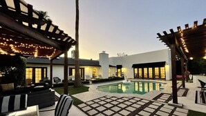 A modern outdoor pool area with a pergola, lounge chairs, and a small fountain. - Kierland Retreat w/Heated Pool & Outdoor Fireplace  (Scottsdale)