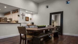 A dining area with a wooden table, cushioned chairs, and a bench. - Kierland Retreat w/Heated Pool & Outdoor Fireplace  (Scottsdale)