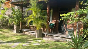 Un espacio de estar al aire libre cubierto con escalones de piedra, rodeado de plantas en macetas y un césped.