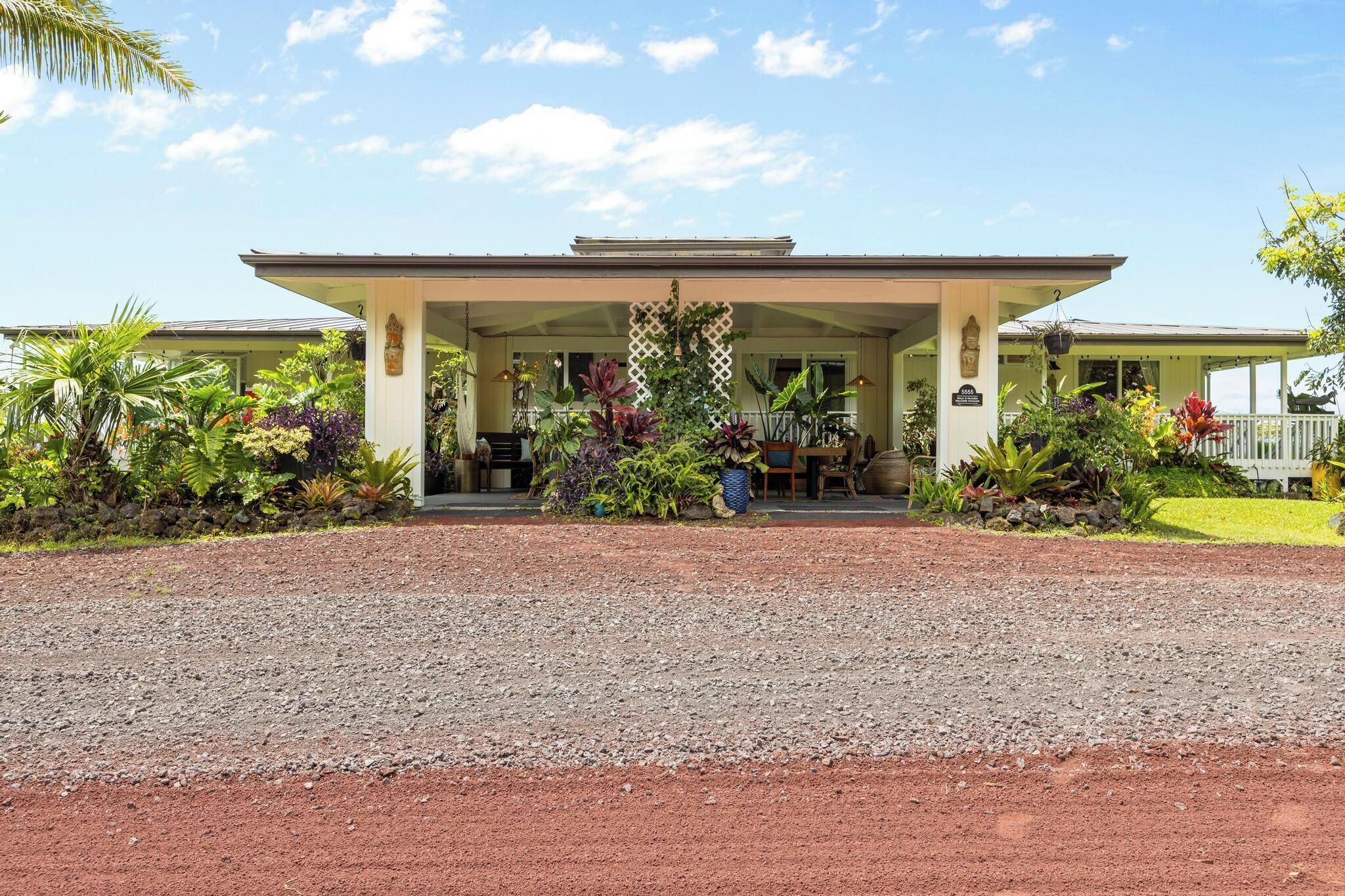 A hotel with a covered entrance, surrounded by lush tropical plants.