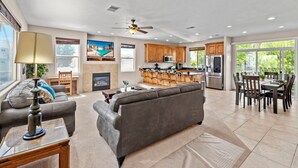 A spacious living area with a sofa, a dining table with chairs, a kitchen with wooden cabinets, and a ceiling fan. - Las Palmas Resort 1805, Resort Access in St George (St. George)