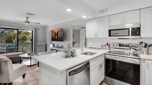 A modern kitchen with white cabinetry, a built-in oven, and a microwave. - Lakeview #6 | 1BR • Remodeled • Beach Access Across Street ✨ (Miramar Beach)