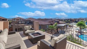 Una terraza en la azotea con mobiliario exterior, una chimenea y una zona de piscina.