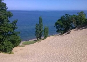 A coastal landscape with a sandy beach, trees, and a clear view of the sea. - Heated Indoor Pool, Fast Wifi, 5 Acres of Fenced Privacy (South Haven)