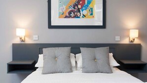 A modern hotel room with a large bed, two bedside tables, and a framed abstract painting on the wall. - Citi Hotel Aberdeen City Centre (Aberdeen)