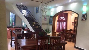 Un comedor con muebles de madera, una escalera y decoración en las paredes.