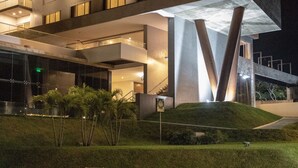 A modern building with a glass facade, outdoor seating, and a well-maintained lawn.