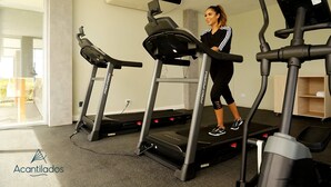 A gym with treadmills and a person using one.