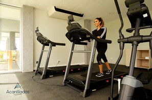 A gym with treadmills and a person using one.