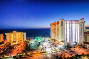 Ein Hotel mit mehreren Etagen, einem Parkplatz und Blick auf das Meer.