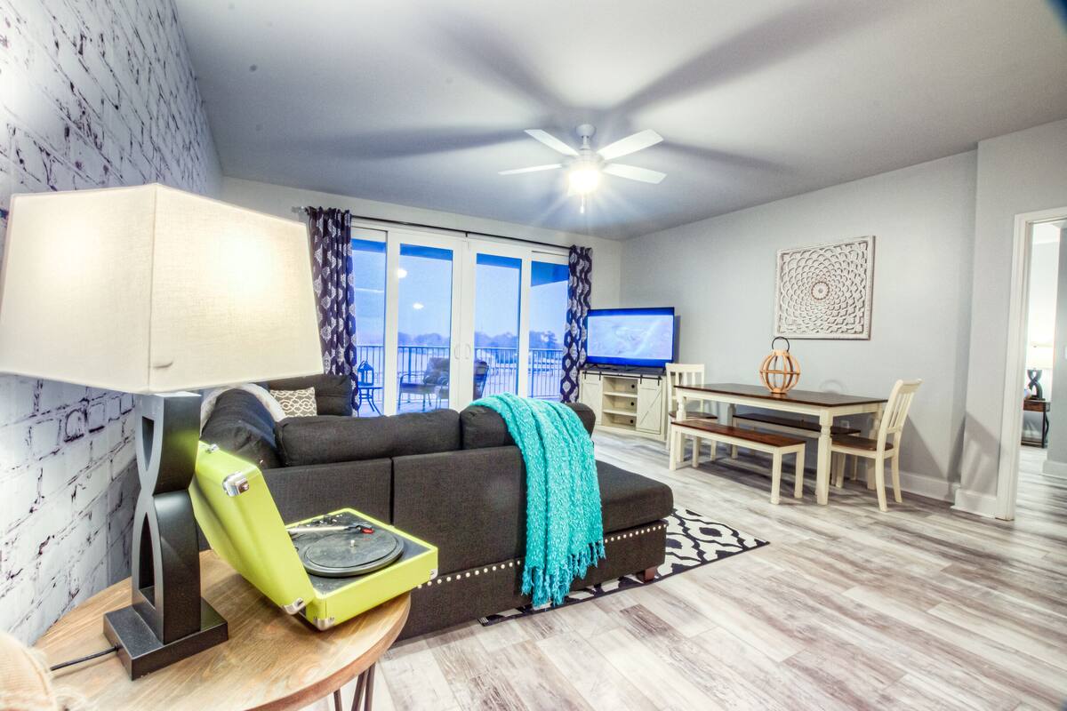 A living room with a sofa, a coffee table, a TV, and a dining area with a table and chairs.