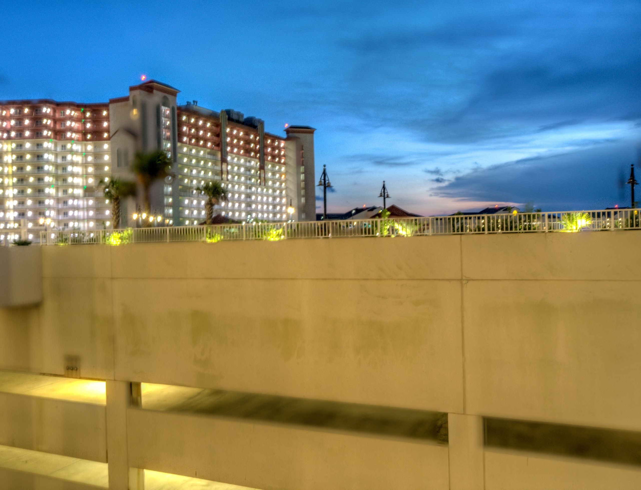 Un hotel con varios pisos, balcones y una fachada bien iluminada.