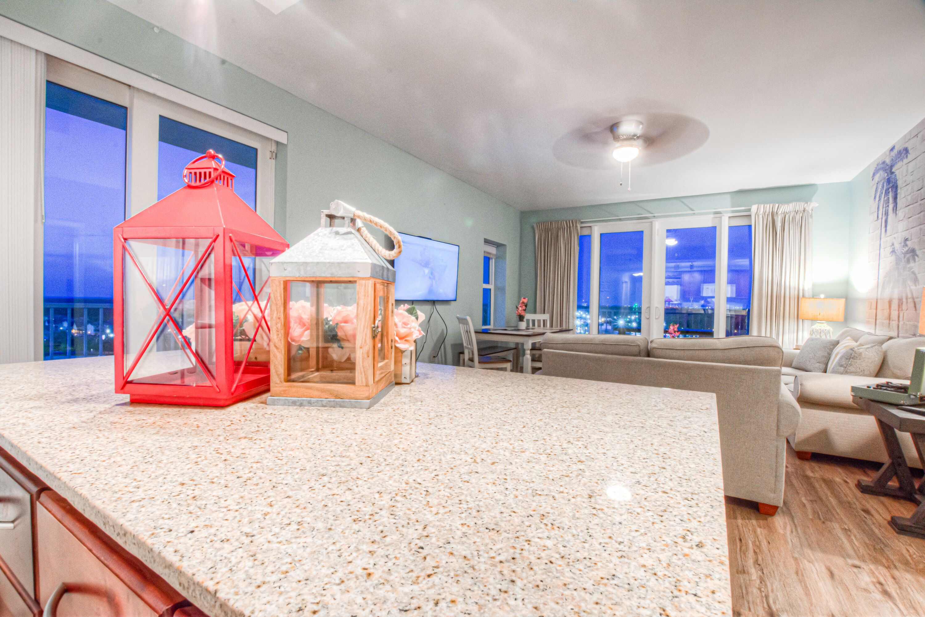 A spacious living area with a large kitchen island, a sofa, and a television.