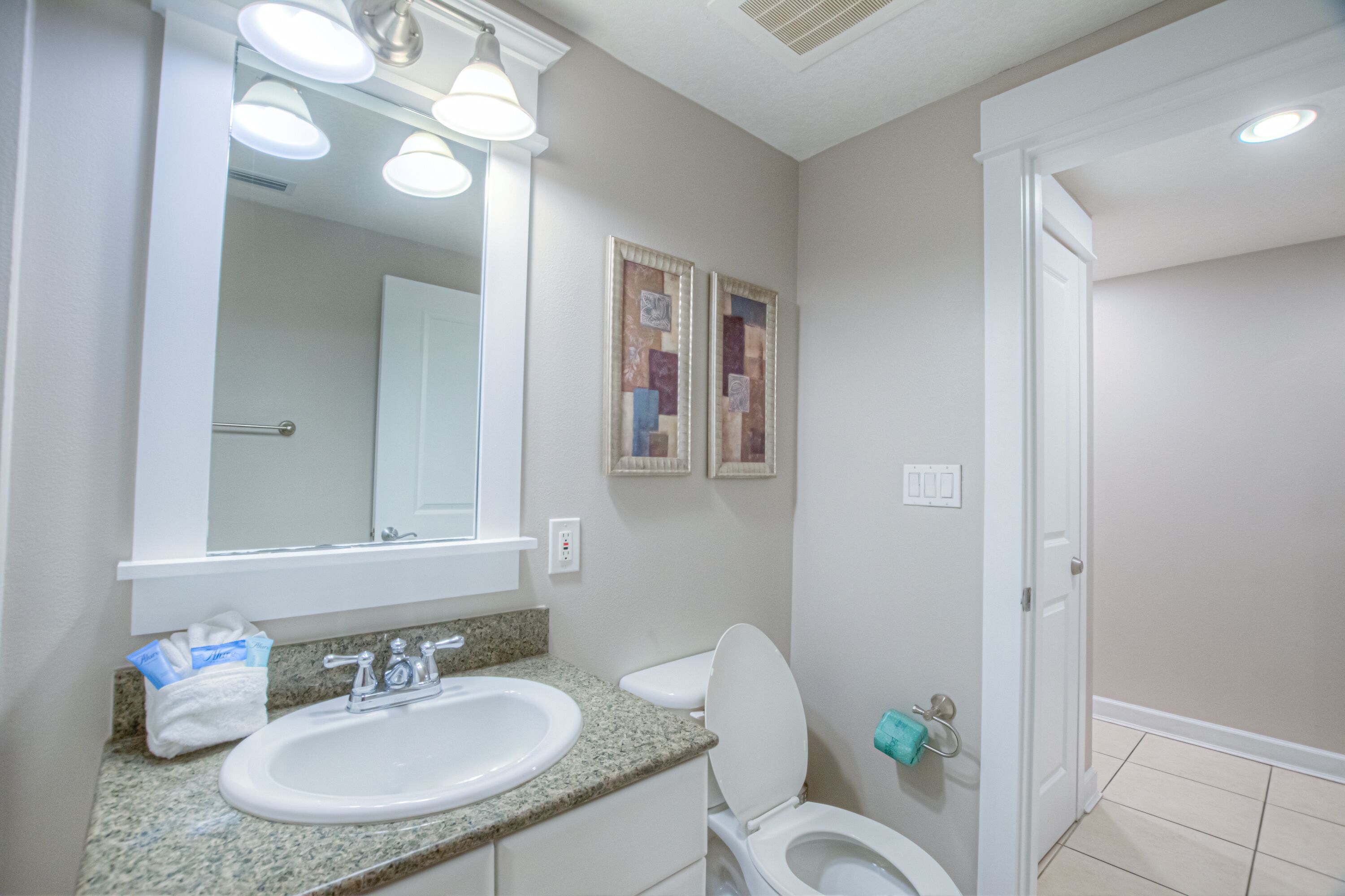 A bathroom with a sink, toilet, and mirror.