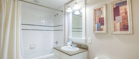 A bathroom with a bathtub, sink, and toilet.