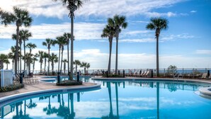 A swimming pool with palm trees and lounge chairs. - Grand Panama by Aneliya's Rentals (Panama City Beach)