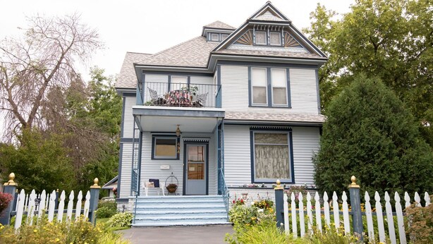 A two-story house with a front porch, a picket fence, and a garden. - Garden Gate BnB (Sturgeon Bay)
