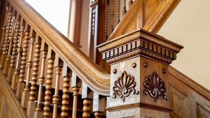 A wooden staircase with ornate balusters and a decorative handrail. - Garden Gate BnB (Sturgeon Bay)
