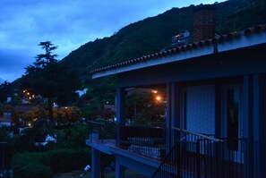 A building with a balcony, surrounded by greenery and hills. - Casa Alta Hotel Boutique Solo Adultos (Villa Carlos Paz)
