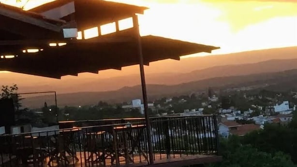 A building with a covered outdoor area, including a balcony with chairs and a railing. - Casa Alta Hotel Boutique Solo Adultos (Villa Carlos Paz)