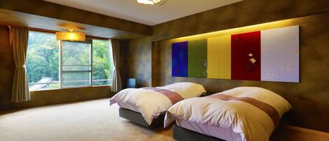 A bedroom with two beds, a large window, and a wall-mounted light fixture.