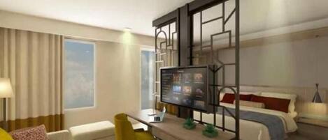 A hotel room with a bed, a desk with a computer, a chair, and a sofa.