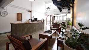A spacious lobby with a reception desk, seating area, and large windows allowing natural light.