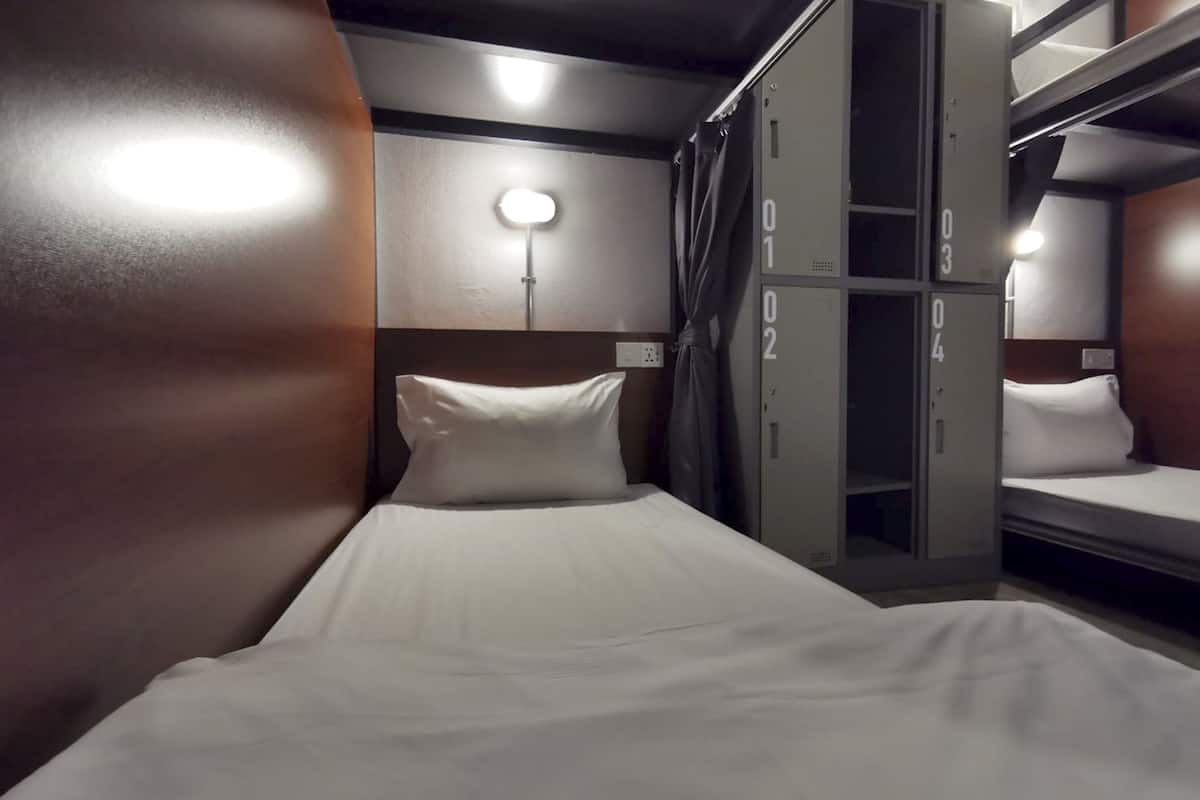 A bunk bed room with a single bed and a wardrobe with numbered compartments.