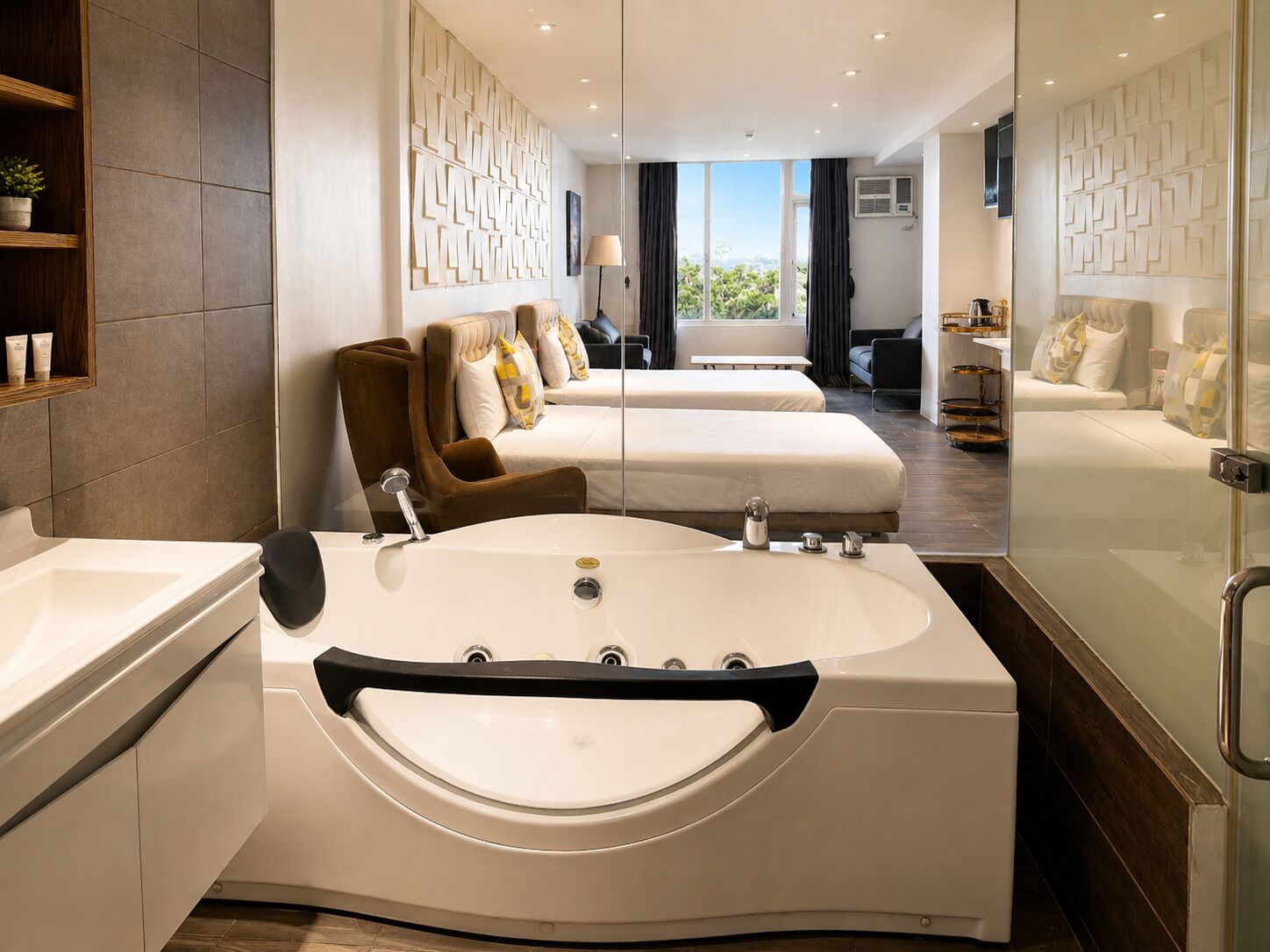 Ein modernes Hotelzimmer mit einer großzügigen Badewanne, zwei Betten, einer Sitzecke und Blick ins Freie.