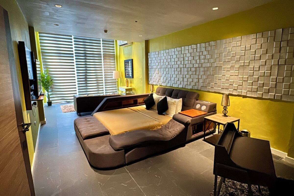 Een moderne slaapkamer met een slaapbank, een nachtkastje en een wandlamp.