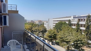 A balcony with a view of a cityscape, including buildings and trees. - Vadim Apartments Vigo Panorama (Nessebar)