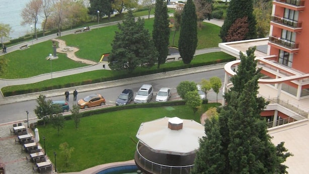 A hotel with a pool, a parking area, and a view of the sea. - Vadim Apartments Vigo Panorama (Nessebar)