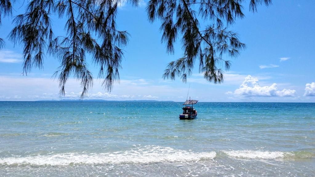 A boat on calm waters with a clear sky and distant land.