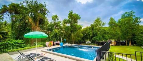 Piscine extérieure, parasols de plage, chaises longues