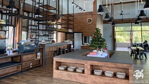Uma cozinha moderna com armários de madeira, uma ilha central com pratos e um pinheiro de Natal.