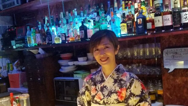 Un bar con estantes llenos de botellas de licor y vasos.