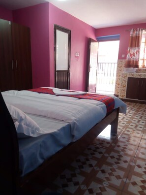 A bedroom with a bed, a wardrobe, a door, and a window. - The Joshua Gardens (Nairobi)