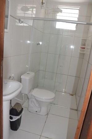 A small, clean bathroom with a toilet, sink, and shower. - Hostel Vila Velha (Vila Velha)
