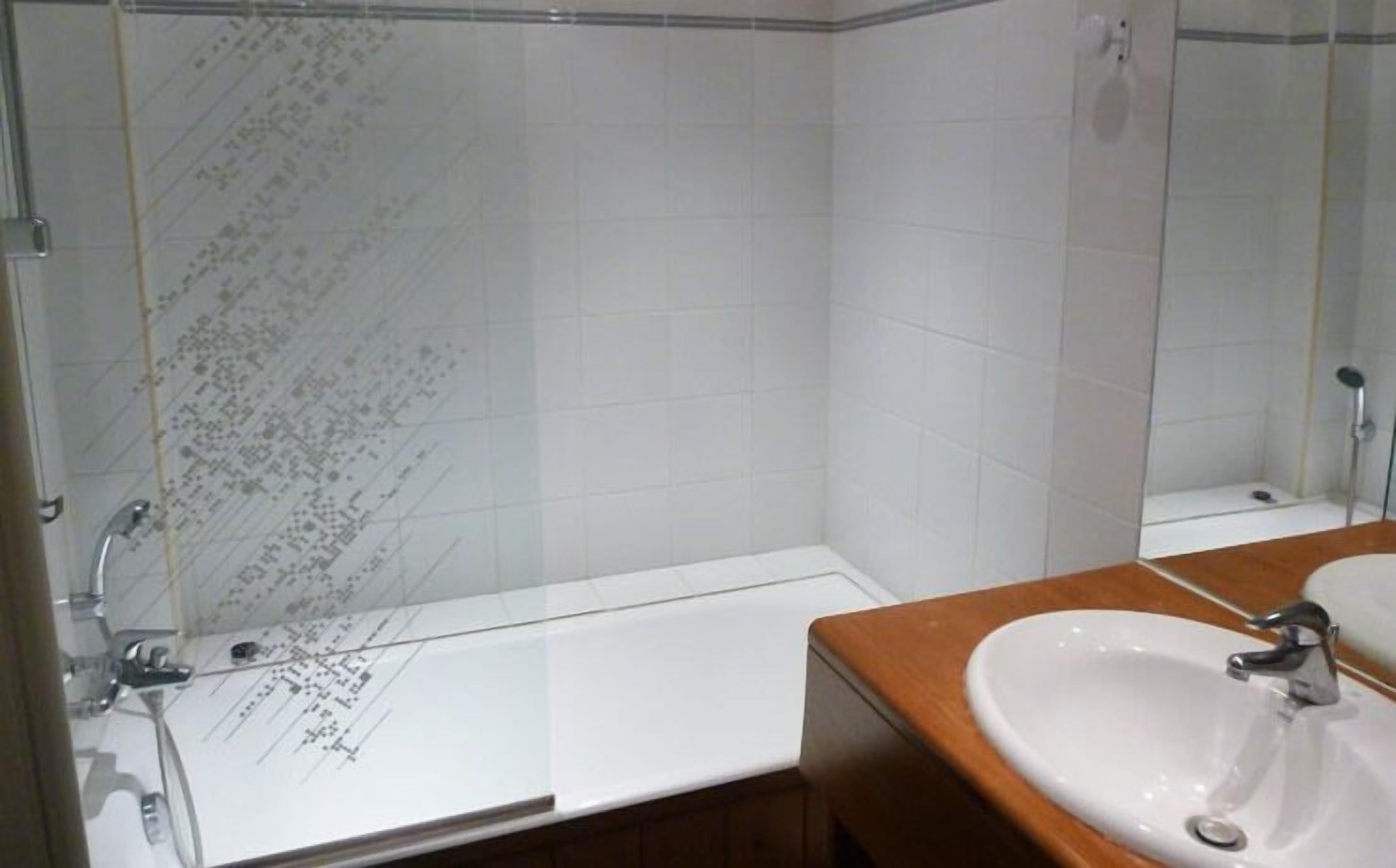 A bathroom with a shower, a bathtub, and a sink.