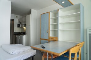 A compact room with a bed, a table, and a kitchenette. - Residence Azureva Piau-Engaly (Aragnouet)